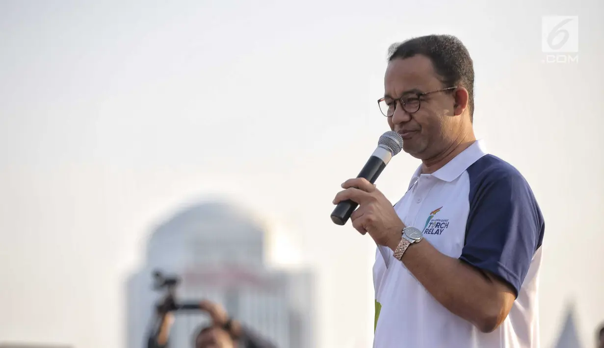 Gubernur DKI Jakarta Anies Baswedan memberi sambutan sebelum acara puncak Kirab Obor Asian Games 2018 di Jakarta, Sabtu (18/8). Anies berharap warga menyimpan merchandise Asian Games sebagai kenang-kenangan dan bukti sejarah. (Liputan6.com/Faizal Fanani)