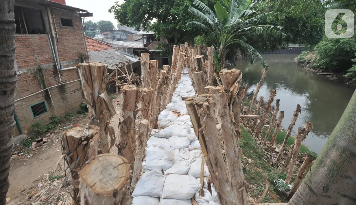 Tanggul dari kayu dan karung pasir dibangun di bantaran Sungai Ciliwung, Rawajati, Pancoran, Jakarta, Senin (11/11/2019). Tanggul dengan panjang 300 meter dan tinggi 1,5 meter itu diharapkan bisa membentengi permukiman warga dari luapan Sungai Ciliwung saat musim hujan. (merdeka.com/Iqbal Nugroho)
