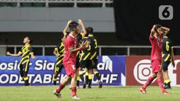 Pemain Timnas U-17 Indonesia, Figo Dennis Saputrananto (kanan) terlihat kecewa saat Malaysia U-17 berhasil mencetak gol pada laga terakhir Kualifikasi Grup B Piala Asia U-17 2023 di Stadion Pakansari, Kab. Bogor, Jawa Barat, Minggu (9/10/2022). Timnas U-17 Indonesia finis di peringkat kedua klasemen Kualifikasi Piala Asia U-17 2023 usai menelan kekalahan 1-5 pada laga terakhir Grup B kontra Malaysia. (Liputan6.com/Helmi Fithriansyah)