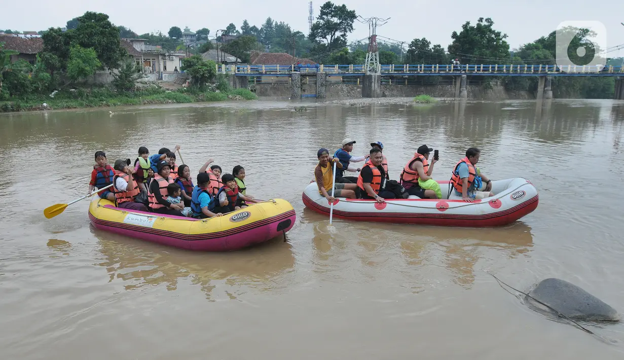 Anak-anak mengikuti rafting pada aliran Sungai Ciliwung di kawasan Bendungan Katulampa, Bogor, Minggu (15/5/2022). Kegiatan bermain sambil mengenalkan alam kawasan daerah aliran sungai (DAS) Ciliwung seperti hiking, menangkap ikan dan rafting yang diadakan oleh Hiking Bocah ini dilakukan setiap akhir pekan dengan biaya Rp 115 ribu/paket anak. (merdeka.com/Arie Basuki)