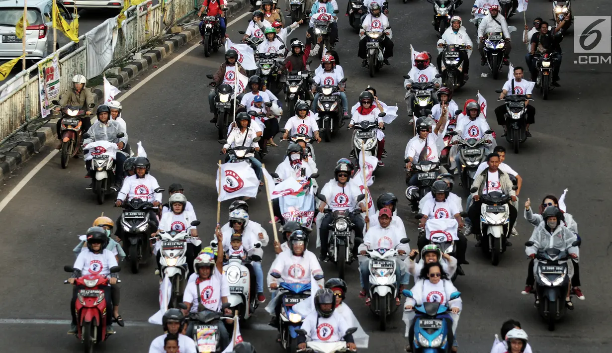 Relawan capres dan cawapres nomor urut 01 Joko Widodo atau Jokowi dan Ma'ruf Amin menggelar konvoi menuju lokasi debat Pilpres 2019 di Jakarta, Minggu (17/2). Massa berkonvoi menggunakan sepeda motor, bus, dan truk. (Liputan6.com/JohanTallo)
