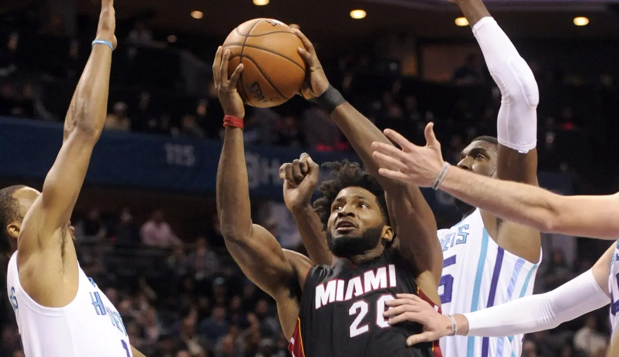 Pemain Miami Heat, Justise Winslow #20 berusaha melewati hadangan para pemain Charlotte Hornets pada laga NBA di Spectrum Center, (29/12/2016). Hornets menang 91-82. (Reuters/Sam Sharpe-USA TODAY Sports)