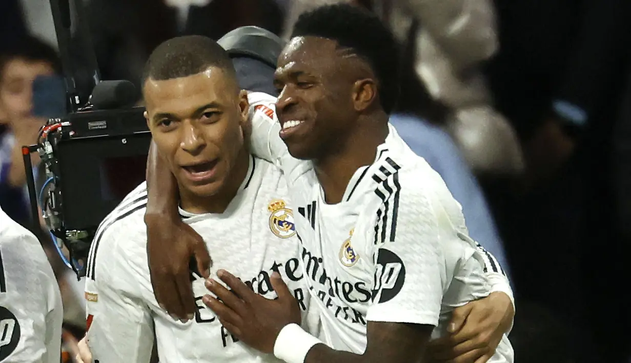 Pemain Real Madrid, Vinicius Junior (kanan) merayakan gol bersama Kylian Mbappe dalam laga lanjutan Liga Spanyol 2024/2025 melawan Girona di Santiago Bernabeu Stadium, Madrid, Minggu (23/02/2025) waktu setempat. (AFP/Pierre-Philippe Marcou)