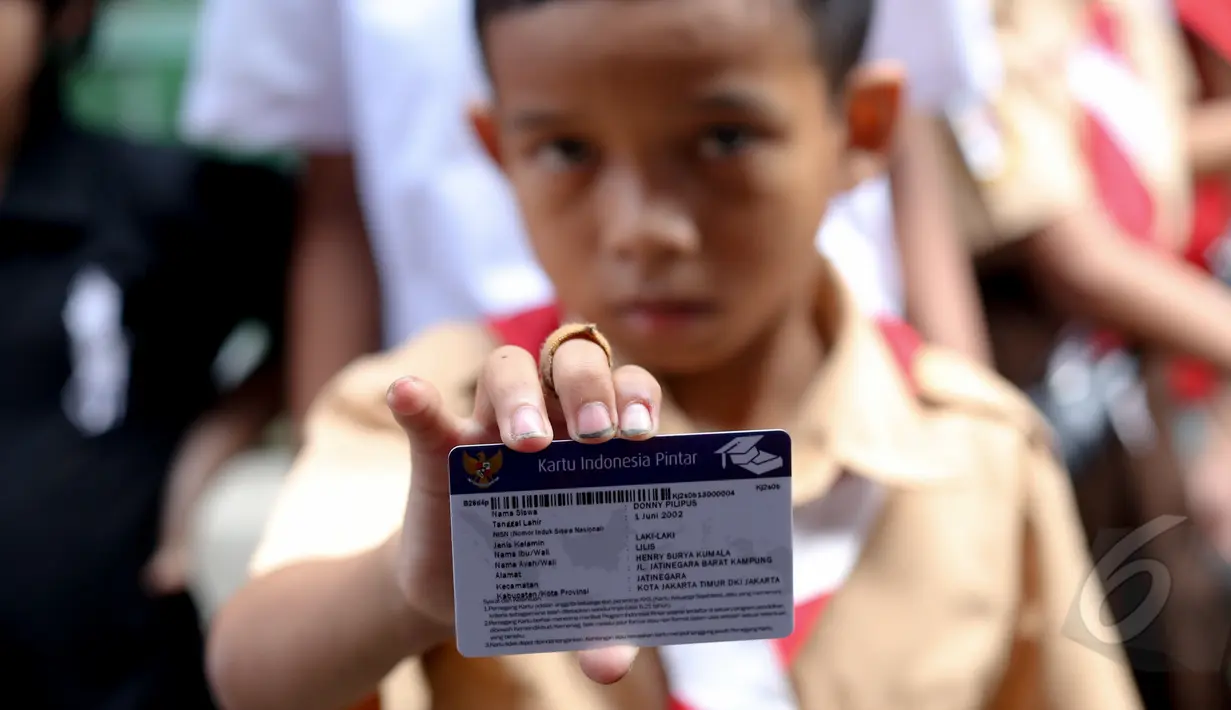 Seorang anak memperlihatkan Kartu Indonesia Pintar di Penjaringan, Jakarta, Rabu (13/5). Pembagian KIS, KIP dan KKS itu untuk meningkatkan kualitas hidup, kesehatan serta pendidikan bagi masyarakat.(Liputan6.com/Faizal Fanani)