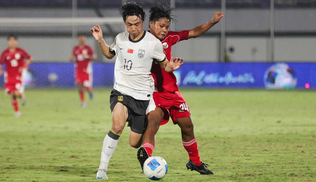 Pemain Timnas Indonesia U-17, Dava Yunna mencoba merebut bola dari pemain China U-17, Jing Feng dalam pertandingan uji coba internasional di Indomilk Arena, Tangerang, pada Rabu (11/2/2026) malam WIB. (Bola.com/Abdul Aziz)