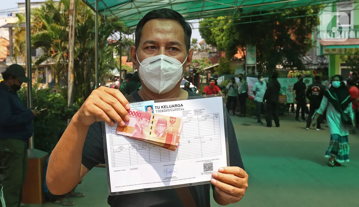 Warga penerima bantuan menunjukkan uang tunai saat penyaluran Bantuan Sosial Tunai (BST) di kawasan Kelurahan Kembangan, Meruya, Jakarta Barat, Minggu (25/07/2021). Penyaluran BST tersebut diperkirakan akan rampung pada 7 Agustus 2021 mendatang. (Liputan6.com/Herman Zakharia)