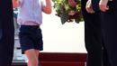 Pangeran George mengusap matanya sambil menggenggam tangan sang ayah, Pangeran William setibanya di Bandara Tegel, Berlin, Rabu (19/7). George ikut dalam tur keluarga kerajaan Inggris bersama Pangeran William dan Kate Middleton. (Kay Nietfeld/dpa via AP)