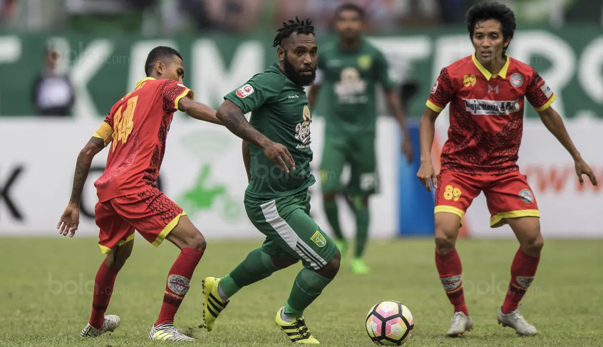 Gelandang Persebaya, Nerius Alom, berusaha melewati kepungan pemain Martapura FC pada laga semifinal Liga 2 2017 di Stadion GBLA, Bandung, Sabtu (25/11/2017). Persebaya menang 3-1 atas Martapura FC. (Bola.com/Vitalis Yogi Trisna)