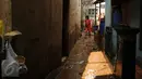 Warga membersihkan sisa lumpur di gang sekitar rumahnya di Rawajati, Kalibata, Jakarta, Senin (16/11/2015). Hujan deras yang melanda Bogor, Minggu (15/11) mengakibatkan puluhan rumah di bantaran sungai Ciliwung terendam. (Liputan6.com/Helmi Fithriansyah)