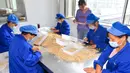 Para staf memilah irisan-irisan ginseng di sebuah ruang produksi di Wanliang, Wilayah Fusong, Provinsi Jilin, China timur laut, pada 28 Agustus 2020. Wanliang terkenal dengan industri ginsengnya. (Xinhua/Xu Chang)