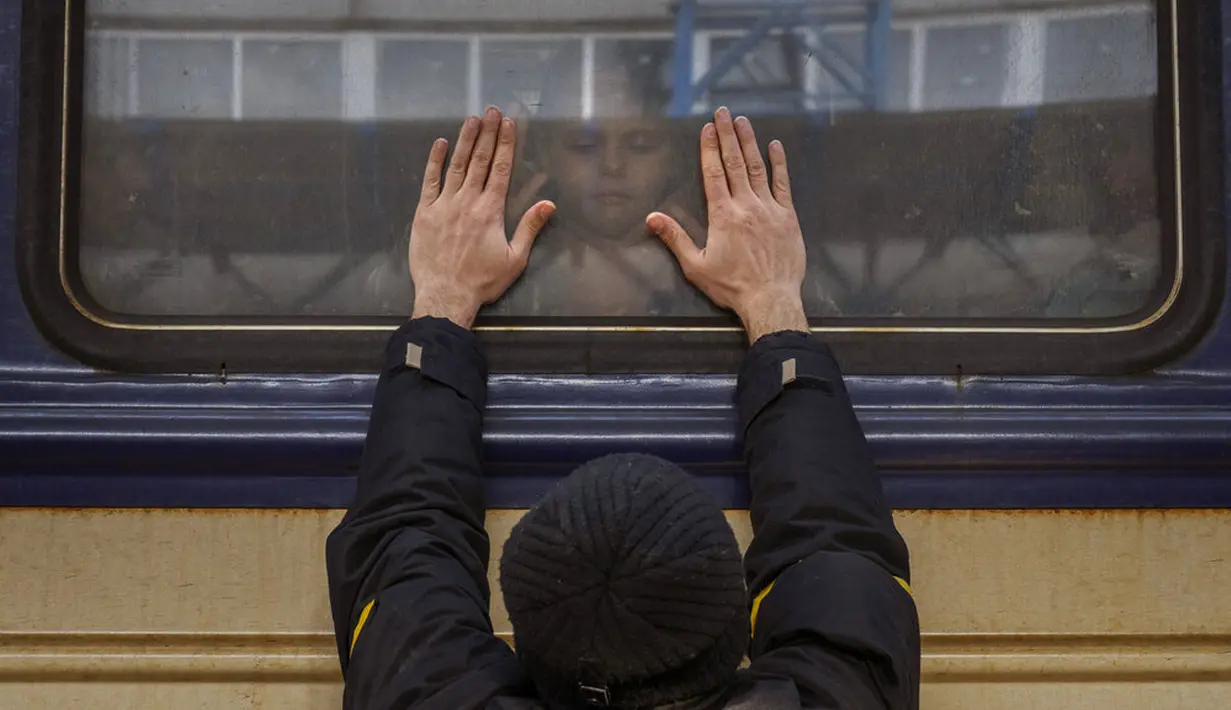Aleksander (41) menempelkan tangan ke jendela saat mengucapkan selamat tinggal kepada putrinya Anna (5) di kereta api ke Lviv di Stasiun Kiev, Ukraina, 4 Maret 2022. Aleksander tinggal untuk berperang, sementara keluarganya meninggalkan Ukraina untuk mencari perlindungan. (AP Photo/Emilio Morenatti)