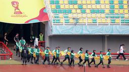 Sejumlah petugas membawa bendera untuk dibentangkan di tengah lapangan sebelum laga Piala Dunia U-17 2023 antara Timnas Mali U-17 melawan Timnas Kanada U-17 di Stadion Gelora Bung Tomo (GBT), Surabaya, Kamis (16/11/2023). (Bola.com/Bagaskara Lazuardi)