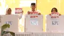Calon Gubernur DKI Jakarta Anies Baswedan bersama istri, Fery Farhati, dan anak perempuannya menunjukkan surat suara sambil berpose salam 3 jari sebelum mencoblos di TPS 028 Cilandak Barat, Jakarta Selatan, Rabu (15/2). (Liputan6.com/Immanuel Antonius)