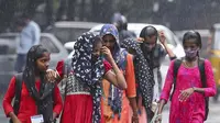 Orang-orang berjalan di tengah hujan di Hyderabad, India, Sabtu, 20 November 2021. Lebih dari selusin orang tewas dan puluhan lainnya dilaporkan hilang di negara bagian Andhra Pradesh, India selatan, setelah berhari-hari hujan lebat, kata pihak berwenang. (AP Photo/Mahesh Kumar A.)