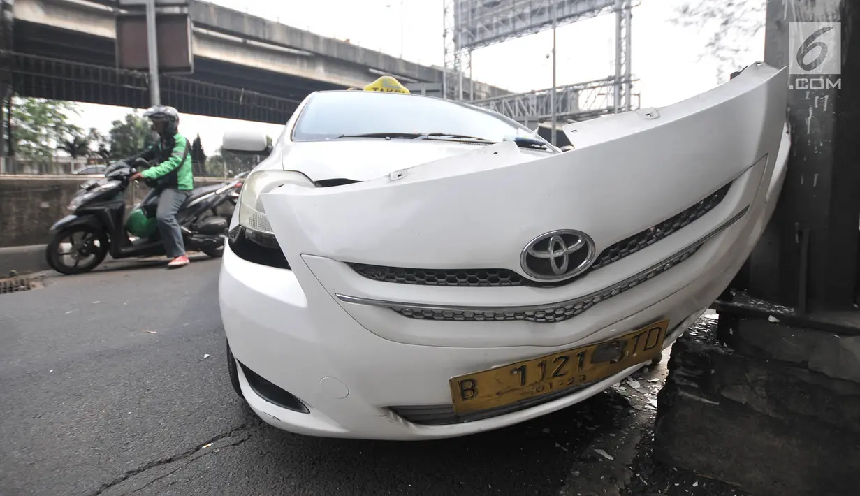 Kondisi taksi yang menabrak tiang di Jalan Ahmad Yani, Jakarta, Rabu (1/8). Mobil taksi berpelat nomor B 1121 BTD tersebut mengalami kerusakan parah pada bagian depan. (Merdeka.com/Iqbal Nugroho)