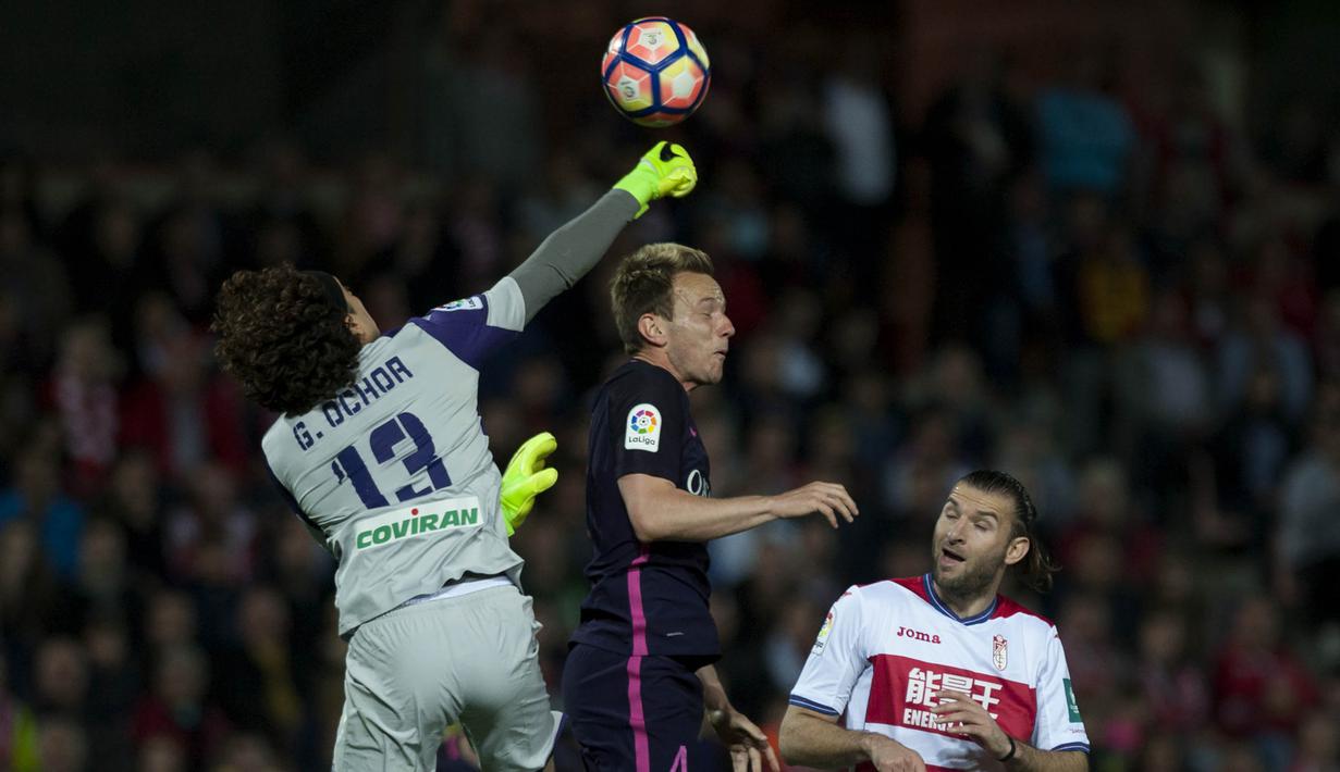 Kiper Granada, Guillermo Ochoa, duel udara dengan gelandang Barcelona, Ivan Rakitic. Kemenangan ini membuat Barcelona masih berada di posisi ke dua menempel ketat Real Madrid di puncak klasemen. (AFP/Jorge Guerrero)