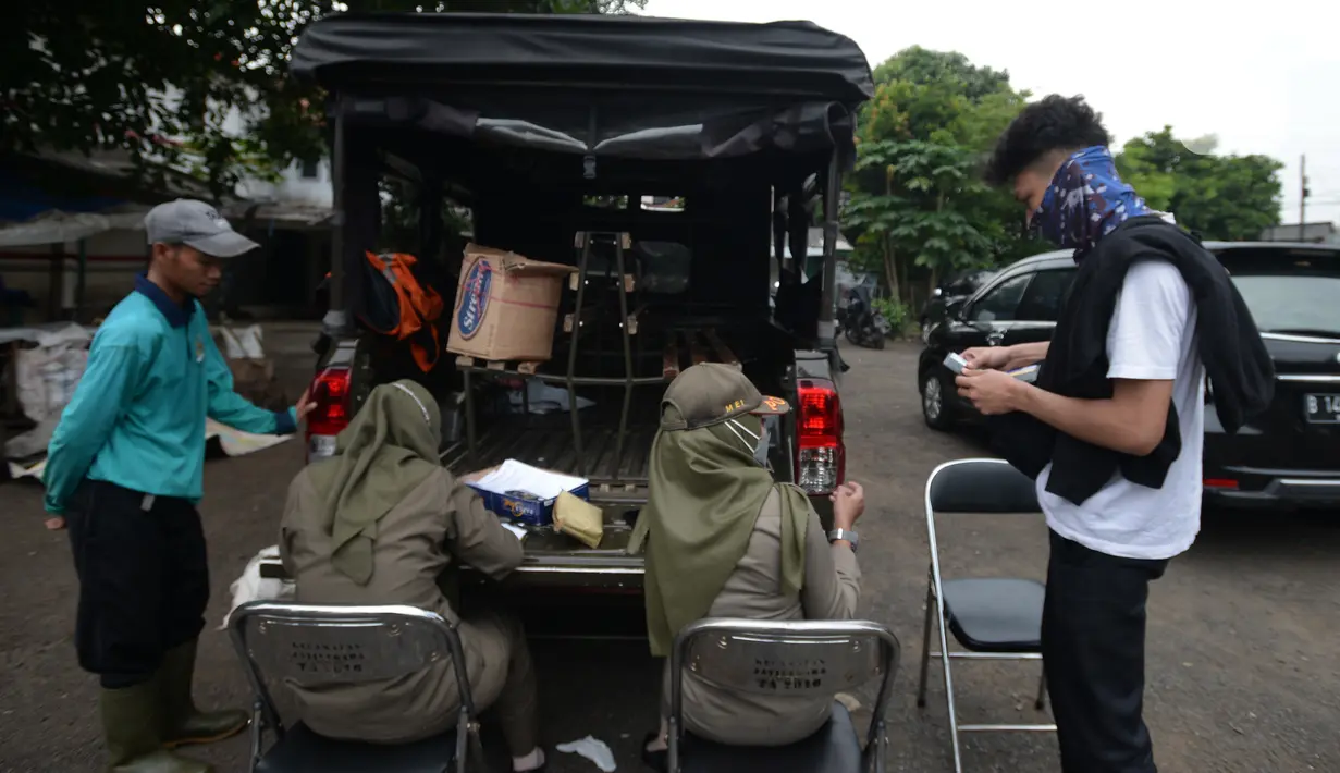 Petugas Satpol PP mendata warga yang terjaring razia protokol kesehatan COVID-19 di Kebon Nanas, Jakarta, Selasa (15/6/2021). Saat kasus positif Covid-19 di Jakarta meningkat, masih banyak warga yang belum menjalankan protokol kesehatan, salah satunya mengenakan masker. (merdeka.com/Imam Buhori)