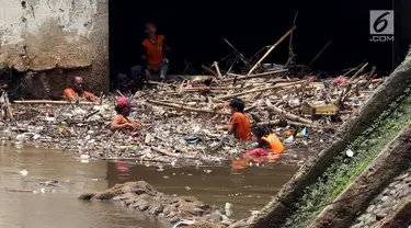 Pasukan Orange mengangkat sampah yang terbawa arus sungai di Pintu air Manggarai, Jakarta, Senin (2/10). Pembersihan itu dilakukan untuk melancarkan aliran Sungai Ciliwung yang melewati Pintu Air Manggarai (Liputan6.com/Johan Tallo)