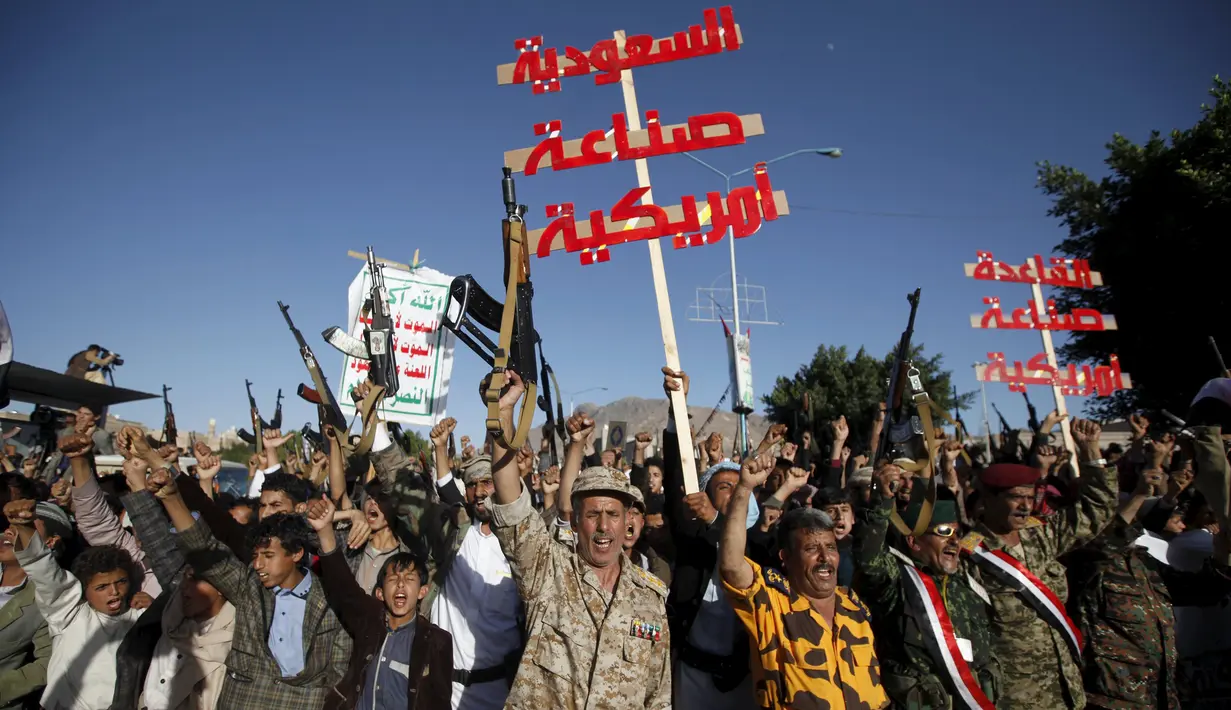 Ratusan kelompok houthi membawa papan yang bertulis "Arab Saudi adalah buatan U.S dan Al-Qaeda adalah buatan U.S selama lakukan demo menentang penyerangan Arab Saudi ke Yaman, Jumat, (20/11). (REUTERS/Khaled Abdullah)