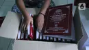 Petugas mengemas Alquran braille yang telah selesai di Yayasan Raudlatul Makfufin (Taman Tunanetra) Buaran, Kota Tangerang Selatan, Jumat (23/4/2021). Dalam kesehariannya, yayasan tersebut dapat memproduksi 5 Alquran braille dengan penyebaran hingga ke luar negeri. (Liputan6.com/Angga Yuniar)