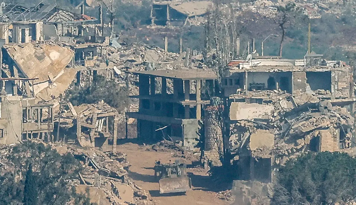 Foto menunjukkan sebuah kendaraan militer Israel melaju di antara rumah-rumah yang hancur di Lebanon Selatan, pada Senin 27 April 2026. (Jalaa MAREY/AFP)