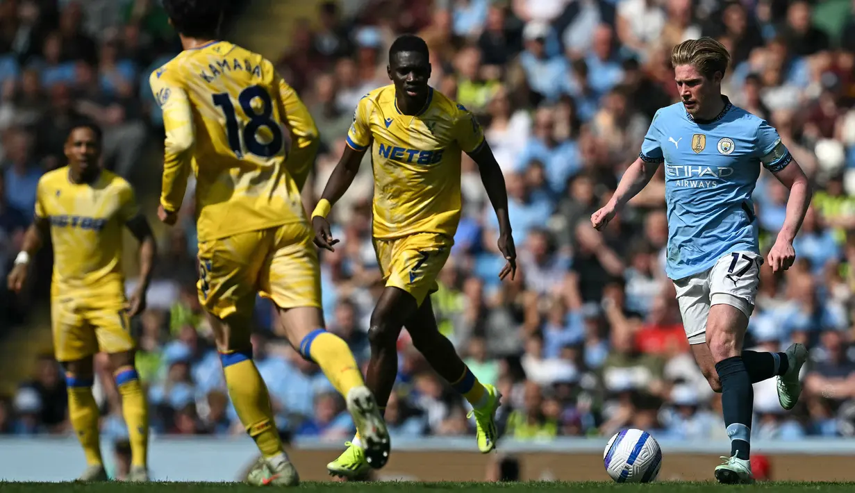 Pemain Manchester City, Kevin De Bruyne berusaha melewati penjagaan sejumlah pemain Leicester dalam laga lanjutan Liga Inggris 2024/2025 di Etihad Stadium, Manchester, Inggris, Sabtu (12/04/2025) waktu setempat. (AFP/Paul Ellis)
