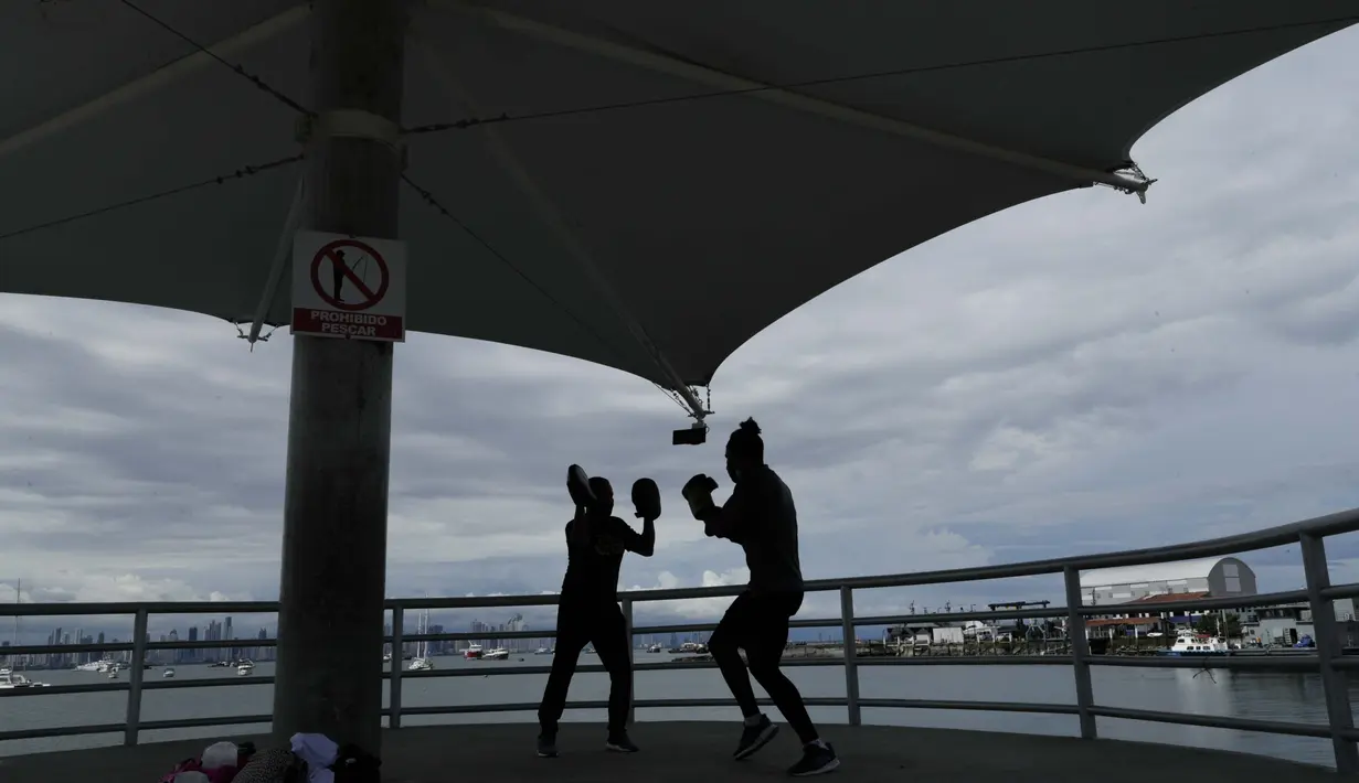 Petinju Kuba Yunier Menen (kanan) dan pelatihnya Carlos Agrazal berlatih di jalan lintas Amador di tengah pandemi COVID-19 di Panama City, Senin (14/9/2020).  (AP Photo / Arnulfo Franco)