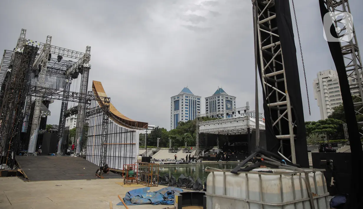 Pekerja memeriksa persiapan panggung yang mulai terpasang untuk acara pertunjukan salah satu stasiun televisi di Taman Lapangan Banteng, Jakarta, Rabu (11/3/2020). Pemprov DKI menangguhkan izin sejumlah kegiatan hiburan terkait pencegahan penyebaran virus corona. (Liputan6.com/Faizal Fanani)