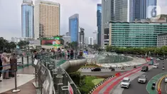 Sejumlah kendaraan bermotor melintas di kawasan Bundaran Hotel Indonesia, ruas Jalan MH Thamrin, Jakarta, Minggu (13/4/2025). (Liputan6.com/Angga Yuniar)