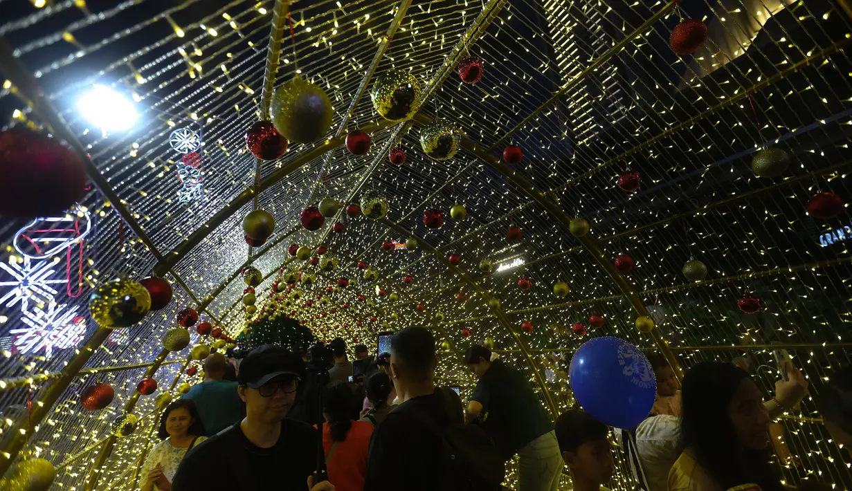 Gemerlap dari lampu-lampu ini tidak hanya berfungsi sebagai penerangan, tetapi disusun untuk menjadi ornamen Natal yang bisa dijadikan spot berfoto atau jalan-jalan santai. Tampak dalam foto, warga menikmati suasana Jakarta Light Festival 2025 di sekitar Bundara Hotel Indonesia, Jakarta, Selasa (23/12/2025). (Kapanlagi.com/Budy Santoso)