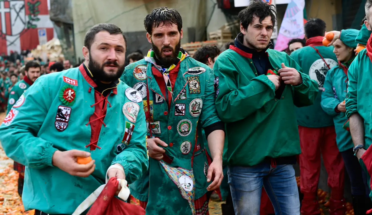 Peserta berpartisipasi pada festival "Battaglia delle Arance" (Perang Jeruk) di kota kecil dekat Turin, Italia, Minggu (11/2). Festival ini berawal di abad ke-19 ketika rakyat memberontak pada raja dengan cara membuang makanan ke jalan (MIGUEL MEDINA/AFP)