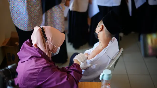 Nampak sejumlah santri di pesantren Al-Masduqiyah tengah melaksanakan vaksinasi di lingkungan pesantren di Garut, Jawa Barat.