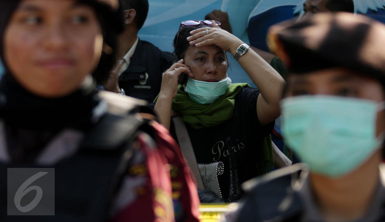 Seorang keluarga korban jatuhnya pesawat Hercules C-130 saat menerima telepon di halaman RSUP Haji Adam Malik, Medan, Sumatera utara, Kamis (2/7/2015). Mereka cemas menanti kepastian kabar anggota keluarganya dari tim DVI. (Liputan6.com/Johan Tallo)