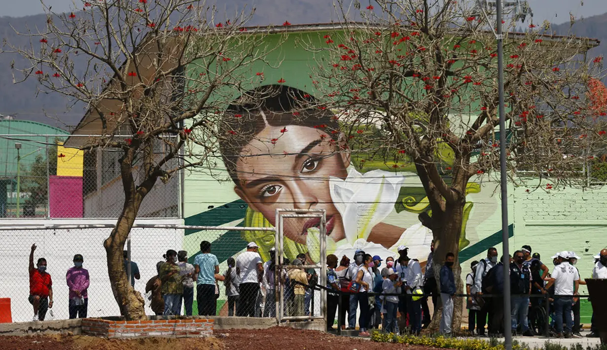 Warga mengantre untuk mendapat kesempatan mencoba sistem angkutan umum baru yang disebut Cablebus di luar stasiun Revolucion Campos, Cuautepec, utara Mexico City, Meksiko, Kamis (4/3/2021). Sistem baru ini akan mengubah perjalanan ke stasiun kereta bawah tanah terdekat. (AP Photo/Rebecca Blackwell)
