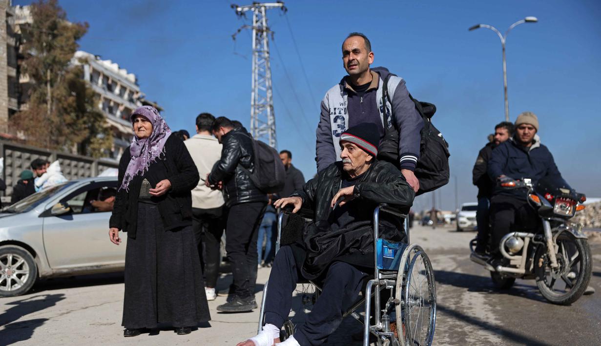 Diketahui, kedua kawasan tersebut diketahui mayoritas dihuni oleh warga etnis Kurdi. Tampak dalam foto, warga lingkungan Sheikh Maqsud dievakuasi dari zona berbahaya oleh anggota pasukan keamanan pemerintah Suriah, di Aleppo pada Sabtu 10 Januari 2026. (OMAR HAJ KADOUR/AFP)