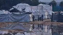 Banjir dengan ketinggian bervariasi merendam permukiman sementara pengungsi Palestina di Gaza. Tampak dalam foto, warga Palestina berdiri di samping area yang tergenang banjir setelah hujan lebat di sebuah kamp pengungsian sementara, Zawaida, Jalur Gaza tengah, Rabu 17 Desember 2025. (AP Photo/Abdel Kareem Hana)