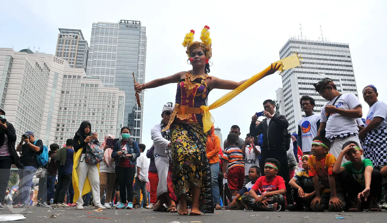 Seniman membawakan Tari Pendet khas Bali dalam parade kebudayaan bertajuk 'Kita Indonesia' di kawasan Bundaran HI, Jakarta, Minggu (4/12). Para peserta Parade Kebudayaan tampak antusias menyaksikan tarian itu. (Liputan6.com/Angga Yuniar)