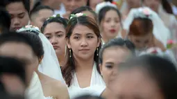 Ekspresi seorang wanita saat bersiap mengikuti pernikahan massal sebagai bagian dari perayaan Hari Valentine di Manila, Filipina (14/2). Sekitar 200 pasangan dilaporkan ikut serta dalam acara tersebut. (AFP Photo/Ted Aljibe)