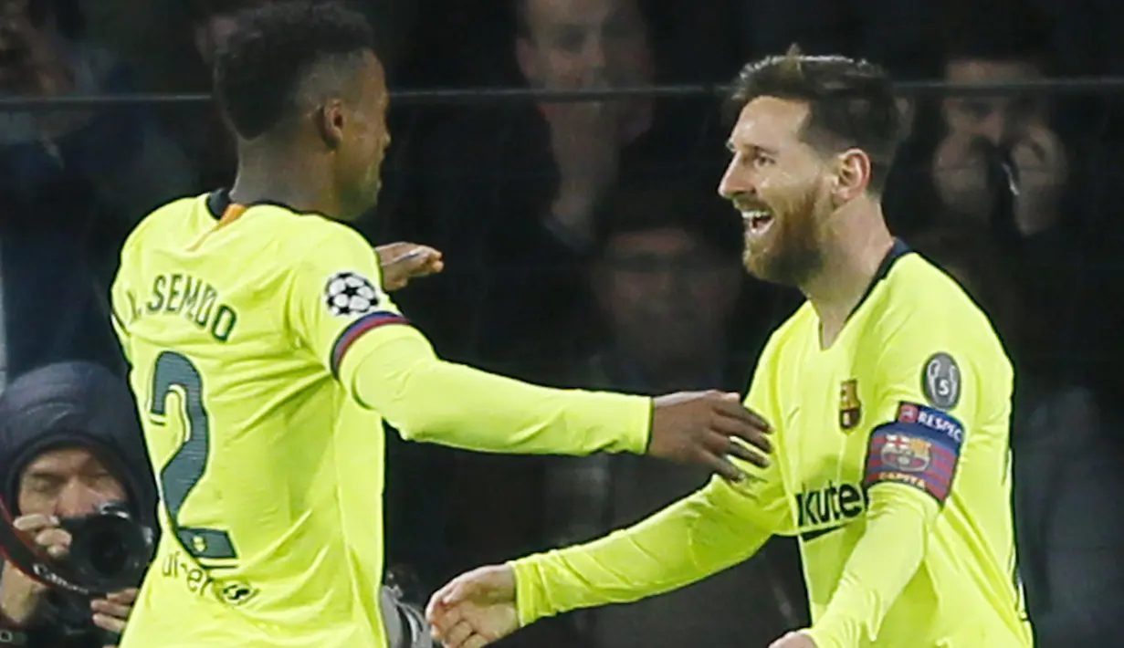 Striker Barcelona, Lionel Messi, bersama Nelson Semedo merayakan gol ke gawang PSV Eindhoven pada laga Liga Champions di Stadion Philips, Rabu (28/11). Barcelona menang 2-1 atas PSV Eindhoven. (AP/Peter Dejong)