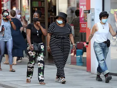 Orang-orang memakai masker saat berjalan di Brussel, Belgia, Rabu (12/8/2020). Penggunaan masker menjadi wajib di tempat umum di Brussel karena kasus Covid-19 naik ke tingkat kewaspadaan yang menempatkan kota itu di antara yang paling parah terkena dampak corona di Eropa. (François WALSCHAERTS/AFP)