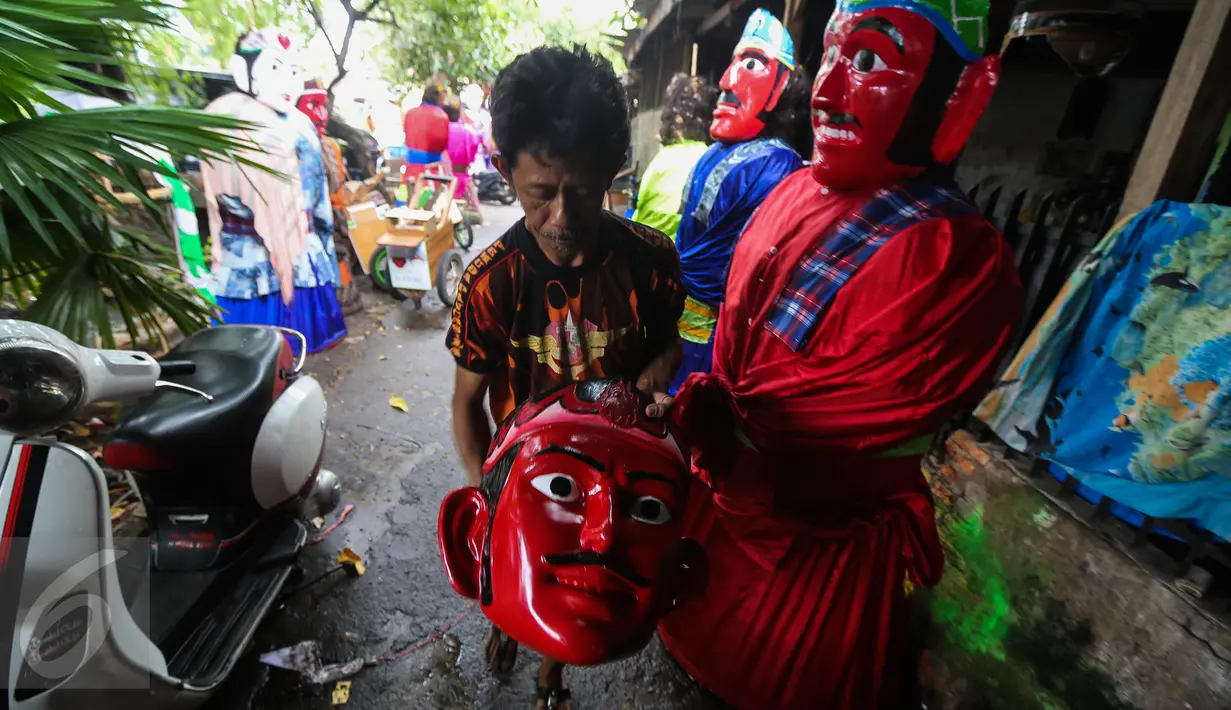 Pengrajin menunjukan hasil pembuatan ondel ondel di kawasan Kramat, Jakarta, Kamis (26/1). Bagian wajah ondel-ondel diibuat berupa topeng atau kedok dengan rambut kepala dibuat dari ijuk. (Liputan6.com/Faizal Fanani)