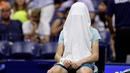 Petenis Italia Jannik Sinner menutupi wajahnya dengan handuk saat pertandingan putaran keempat melawan Alexander Zverev (Jerman) pada kejuaraan tenis AS Terbuka, Senin, 4 September 2023, di New York. (AP Photo/Adam Hunger)
