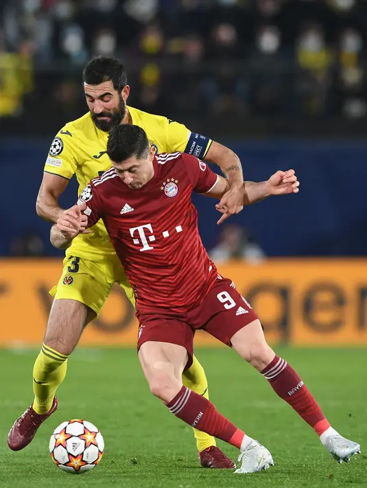 Bek Villarreal, Raul Albiol melakukan pelanggaran terhadap penyerang Bayern Munchen, Robert Lewandowski pada pertandingan leg pertama perempat final Liga Champions di stadion La Ceramica di Vila-real, Kamis (7/4/2022). Villarreal menang tipis atas Bayern Munchen 1-0. (AFP/Christof Stache)