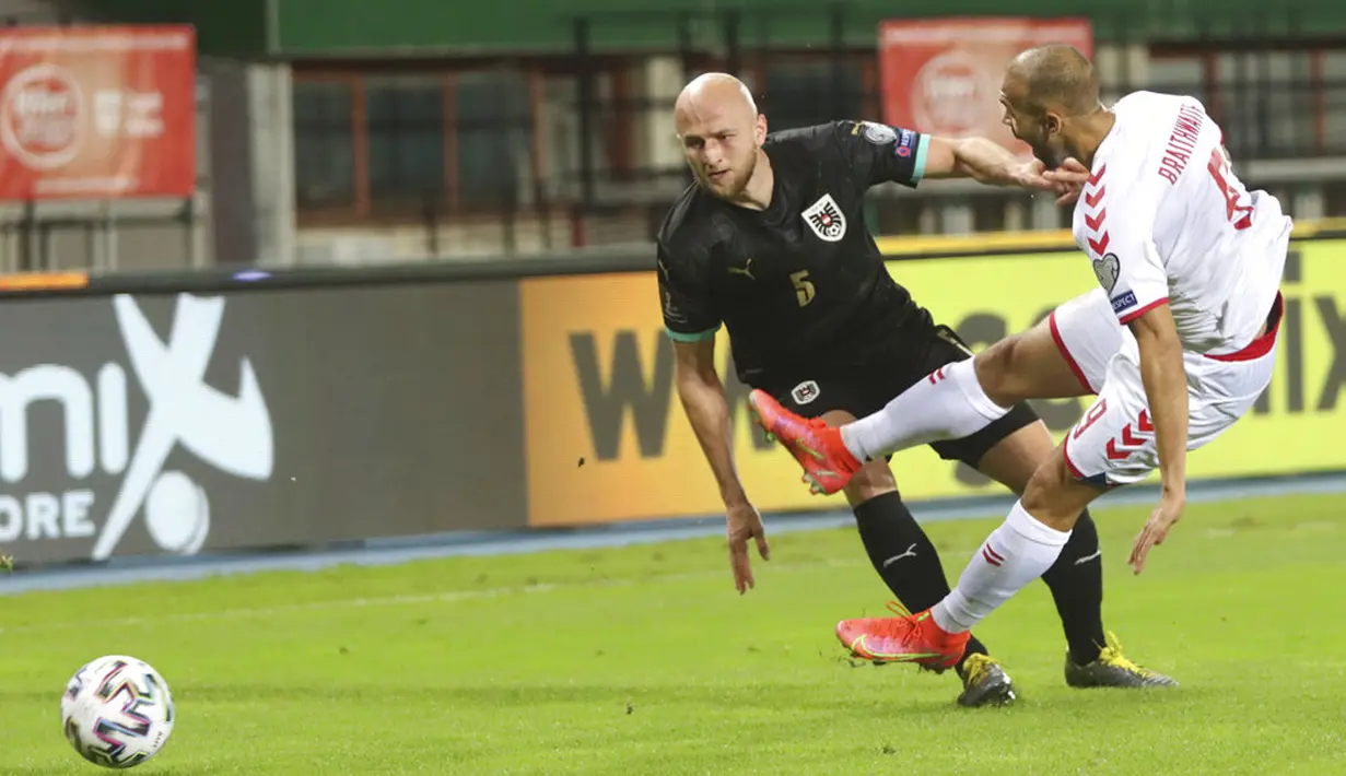 Pemain Denmark Martin Braithwaite (kanan) memperebutkan bola dengan pemain Austria Gernot Trauner pada pertandingan Grup F kualifikasi Piala Dunia 2022 di Ernst-Happel-Stadium, Wina, Austria, Rabu (31/3/2021). Denmark membantai Austria 4-0. (AP Photo/Ronald Zak)