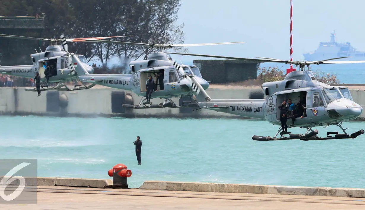 Anggota TNI AL melakukan terjun dari helikopter saat peringatan HUT TNI ke-70 di Dermaga Indah Kiat, Cilegon, Banten, Senin (5/10/2015). HUT TNI Ke-70 ditandai atraksi tempur tiga matra TNI Angkata Darat, Laut dan Udara. (Liputan6.com/Faisal Fanani)