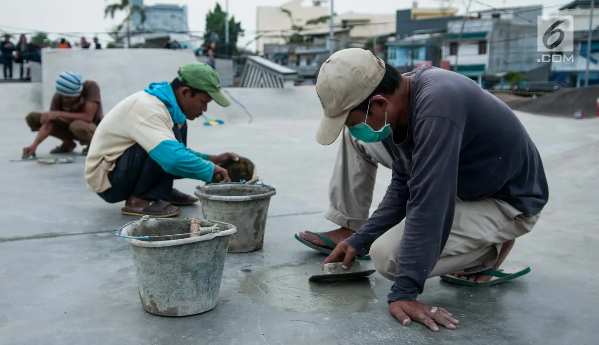 Pekerja melakukan penambalan arena skateboard di Kalijodo, Jakarta, Jumat (2/6). (Liputan6.com/Gempur M Surya)