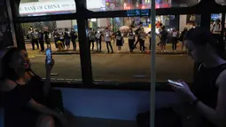 Demonstran prodemokrasi terlihat dari dalam trem sedang membentuk rantai manusia di jalanan Hong Kong, Jumat (23/8/2019). Dengan bergandengan tangan dan menyanyikan lagu-lagu, puluhan ribu demonstran berjejer di trotoar, jembatan layang, dan taman-taman Hong Kong. (AP Photo/Kin Cheung)