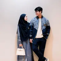 Serasi dengan Rizky Billar, Lesti Kejora mengenakan gamis biru motif parang dipadukan kerudung panjang navy. Sambil membawa tas putih serasi dengan sepatunya. [@lestykejora]