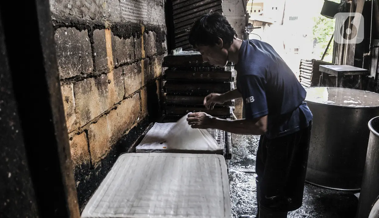 Pekerja menyelesaikan pembuatan tahu di industri rumahan kawasan Mampang, Jakarta, Minggu (30/8/2020). Menurunnya produksi disebabkan pelanggan, terutama pengusaha warung makan yang terpaksa tutup akibat diterapkannya PSBB sehingga berpengaruh pada omzet penjualan. (merdeka.com/Iqbal S. Nugroho)