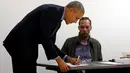 Presiden AS Barack Obama mengisi buku tamu setibanya di TPS awal di pusat kota Chicago, Illinois, Jumat (7/10). Obama memberikan suaranya lebih dahulu untuk Pilpres AS pada 8 November 2016 mendatang. (REUTERS/Jonathan Ernst)